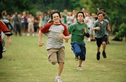 a group of boys running on grass